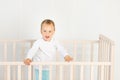 Baby in the crib waiting for mom, baby 2 years in the crib Royalty Free Stock Photo