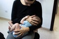 Baby crying after vaccination with band aid or plaster in the thigh, comforted by his mother who breastfeeds him