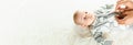 Baby cute child banner. Happy cute baby kid girl lying on white bed background. Light background. Little child. Serious Royalty Free Stock Photo