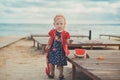 Baby cute girl with blond hair and pink apple cheek enjoying summer time holiday posing in beautiful beach full of sand wearing st Royalty Free Stock Photo