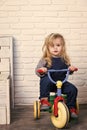 Baby cyclist with long blond hair on white brick wall Royalty Free Stock Photo