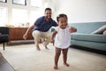 Baby Daughter Dancing With Father In Lounge At Home