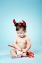 Baby with devil horns on blue background Royalty Free Stock Photo