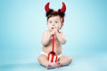 Baby with devil horns on blue background Royalty Free Stock Photo