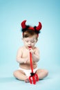 Baby with devil horns on blue background Royalty Free Stock Photo