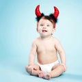 Baby with devil horns on blue background Royalty Free Stock Photo