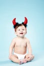 Baby with devil horns on blue background Royalty Free Stock Photo