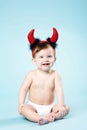 Baby with devil horns on blue background Royalty Free Stock Photo