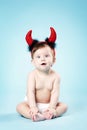 Baby with devil horns on blue background Royalty Free Stock Photo