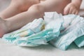 Baby diapers and a small child sitting next to him, close-up Royalty Free Stock Photo