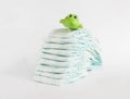 Baby diapers on a white background and a children`s toy frog Royalty Free Stock Photo