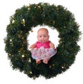 Baby doll sitting on christmas wreath Royalty Free Stock Photo