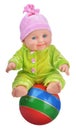 Baby doll sitting on striped beach ball