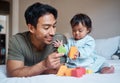 Baby, down syndrome and learning on a bed with child and father playing with educational blocks in a bedroom. Family Royalty Free Stock Photo