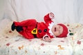 Baby dressed as Santa Claus is naughty in bed