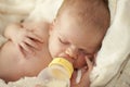 Baby drinking from bottle with nipple in mouth Royalty Free Stock Photo