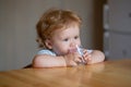 Baby drinking glass of water. Healthy nutrition for kids. Portrait of little baby having drink in domestic environment.