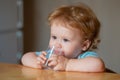 Baby drinking glass of water. Healthy nutrition for kids. Portrait of little baby having drink in domestic environment.