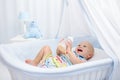 Baby drinking milk. Boy with formula bottle in bed Royalty Free Stock Photo