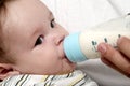 Baby drinking milk of her bottle