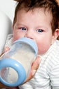 Baby drinking milk of her bottle