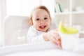 Baby drinking from spout cup in highchair at home Royalty Free Stock Photo