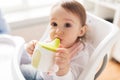 Baby drinking from spout cup in highchair at home Royalty Free Stock Photo