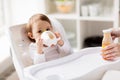 Baby drinking from spout cup in highchair at home Royalty Free Stock Photo