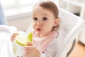 Baby drinking from spout cup in highchair at home Royalty Free Stock Photo