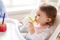 Baby drinking from spout cup in highchair at home Royalty Free Stock Photo