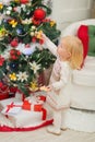 Baby eating cookies near Christmas tree