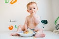 Baby eating by himself learning through the Baby-led Weaning method, exploring the flavors of food with curiosity