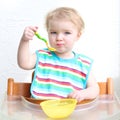 Baby eating porridge from bowl Royalty Free Stock Photo