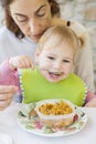 Baby eating rice from tupperware