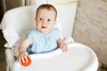 Baby eating vegetables. red tomato in little girl hand in sunny kitchen. Healthy nutrition for kids. Snack or breakfast for young Royalty Free Stock Photo