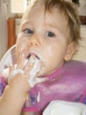 Baby eating yogurt with her hand Royalty Free Stock Photo