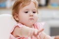 A baby eating yogurt with some on her face. Royalty Free Stock Photo