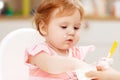 A baby eating yogurt with some on her face. Royalty Free Stock Photo