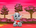 Baby elephant holding a red heart in the forest Royalty Free Stock Photo