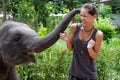 Baby elephant play with female teenager