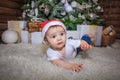 Baby in elf costume playing with old wooden train and soft toy bears under the Christmas tree, vintage. Royalty Free Stock Photo