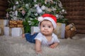 Baby in elf costume playing with old wooden train and soft toy bears under the Christmas tree, vintage. Royalty Free Stock Photo