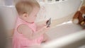 Baby entertainment concept. Cute baby with mobile watching animation in bed Royalty Free Stock Photo