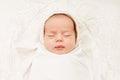 Baby Face Close up Portrait with Closed Eyes. Newborn Sleeping in White Hat wrapped in Swaddle over Blanket. Infant Health Care Royalty Free Stock Photo