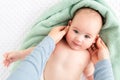 Baby face massage background. Mother gently stroking baby boy face with both hands. Close up cropped shot.