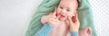 Baby face massage banner with copy space. Mother gently stroking baby boy face with both hands. Close up cropped shot. Royalty Free Stock Photo