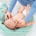 Baby face massage. Mother gently stroking baby boy face with both hands. Close up cropped shot. Royalty Free Stock Photo