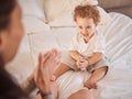 Baby, family and child clapping hands, happy and having fun on bed playing with his mother at home. Cute kid, son or Royalty Free Stock Photo