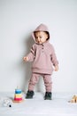 Baby fashion. Unisex clothes for babies. Cute baby in cotton set suit on light background.