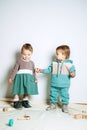 Baby fashion. Unisex gender neutral clothes for babies. Two Cute baby girls in neutral color palette cotton cloth